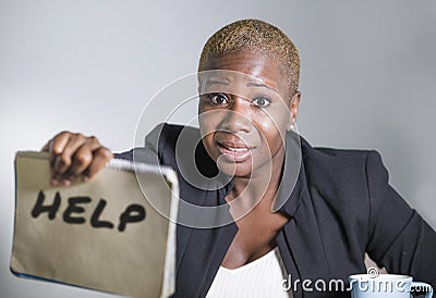 Sad and depressed black afro American woman suffering stressed at office working with laptop computer feeling overwhelmed asking f Stock Photo