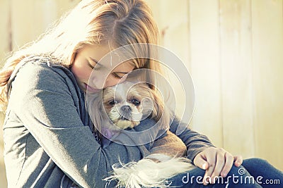 A sad or depressed teenage girl hugging a small dog Stock Photo