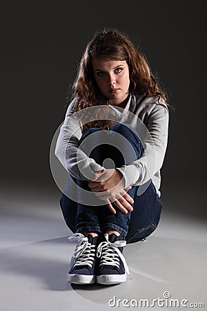 Sad depressed young teenager girl sitting alone Stock Photo