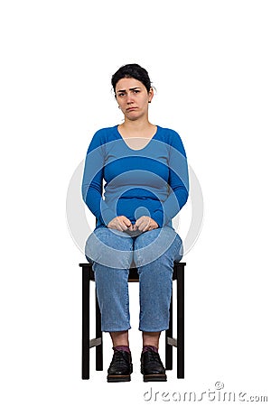 Sad and disappointed woman sitting on a chair looking indisposed to camera, full length isolated over white background. Upset Stock Photo