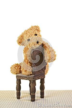 Sad depressed Teddy bear sitting on chair Stock Photo