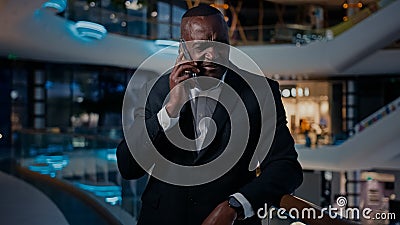 Sad ethnic middle-aged man African American entrepreneur answer phone call talking smartphone talk cellphone listen bad Stock Photo