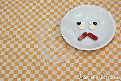 Sad face made of medicine. pain medication tablets. colored pills on porcelain dish. Assorted pharmaceutical pills Stock Photo