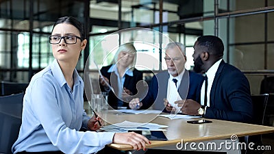 Sad female manager looking window during office meeting, workload tiredness Stock Photo