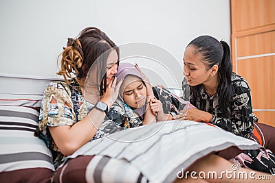 a sad friend is comforted by two friends in the bedroom Stock Photo