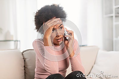 Sad frightened shocked frustrated millennial african american female, call and talk by smartphone, suffer from stress Stock Photo