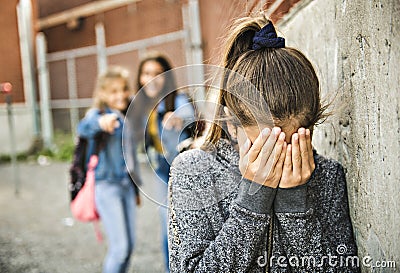 A sad girl intimidation moment on the elementary Age Bullying in Schoolyard Stock Photo