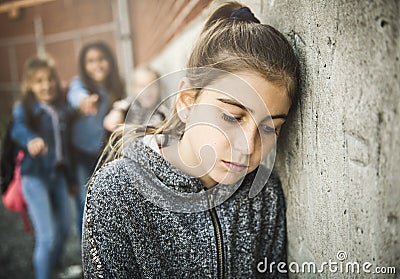 A sad girl intimidation moment on the elementary Age Bullying in Schoolyard Stock Photo