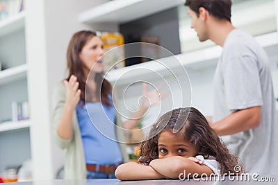 Sad girl listening to her parents arguing Stock Photo