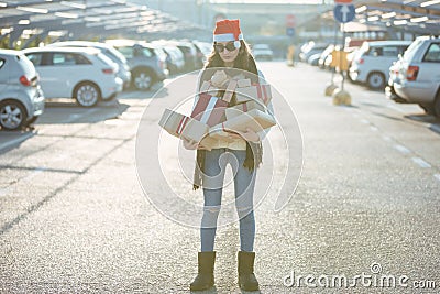 Sad girl with a lot of boxes and santa`s red hat spent too much money for xmas presents Stock Photo