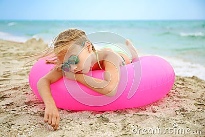 Sad girl lying on pink inflatable circle Stock Photo