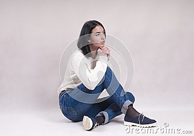 Sad girl sits on the floor in jeans news depression solitude difficulties Stock Photo