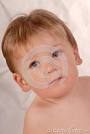 Sad little baby boy poses for camera tilted Stock Photo