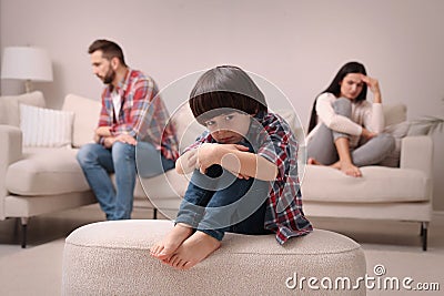 Sad little boy and his arguing parents on sofa in living room Stock Photo