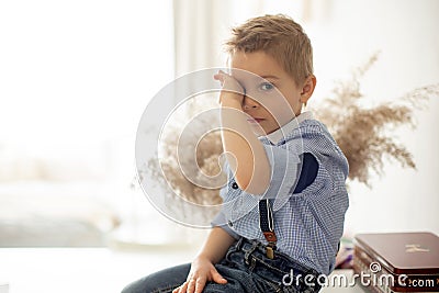 Sad little child, hurt, sitting at home, crying Stock Photo