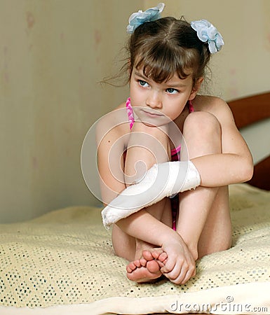 Sad little girl with bandaged hand Stock Photo