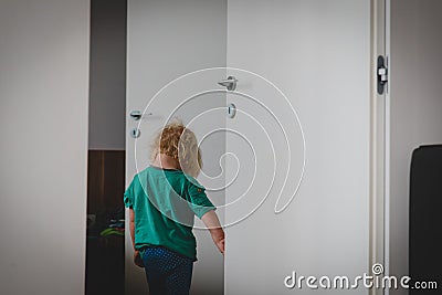 Sad little girl going out and closing doors, child offence Stock Photo