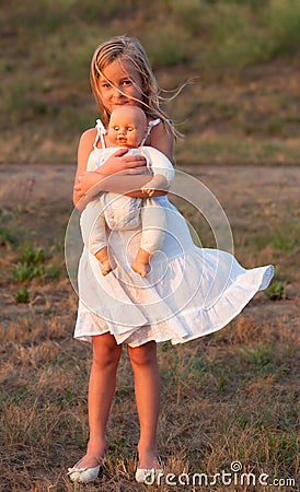 Sad little girl standing alone and holding her toy Stock Photo