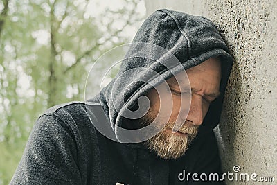A sad and lonely man at the wall Stock Photo