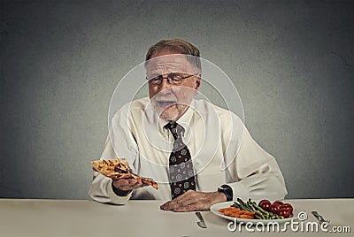 Sad man looking at pizza tired of salad diet Stock Photo