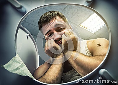 Sad man looking in the toilet bowl Stock Photo