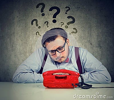 Worried man with too many questions waiting for a call Stock Photo