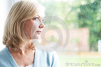 Sad Mature Woman Suffering From Agoraphobia Looking Out Of Window Stock Photo