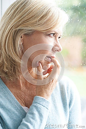 Sad Mature Woman Suffering From Agoraphobia Looking Out Of Window Stock Photo