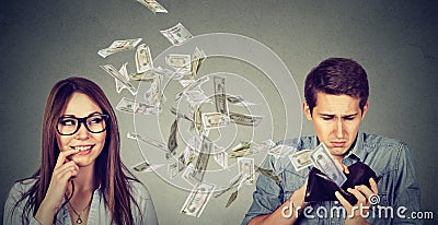 Sad man looking at his wallet with money dollar banknotes flying away towards flirting cute young woman Stock Photo