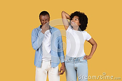 African American man chuckling with his hand over his mouth while the woman beside him looks up Stock Photo