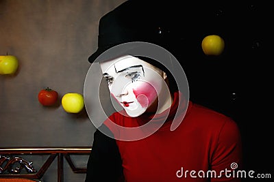 Sad mime in a hat with apples Stock Photo