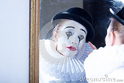 Sad mime Pierrot looking at the mirror Stock Photo