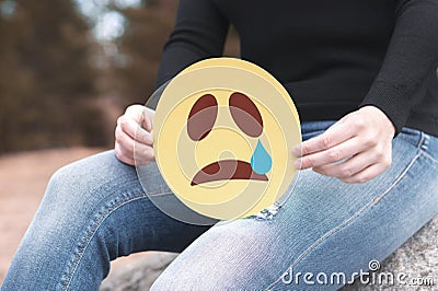 Sad paper emoticon in hand. Stock Photo