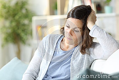 Sad pensive middle age woman looking down at home Stock Photo