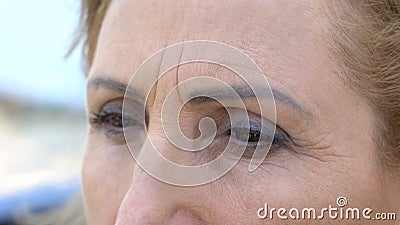 Sad senior woman looking in distance, eyes close up, feeling homesickness Stock Photo