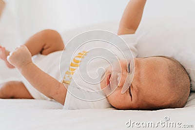 Unhappy Asian newborn baby crying at home Stock Photo