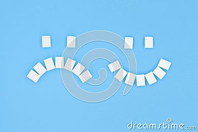 Sad and smiling face made from cubes of white sugar Stock Photo