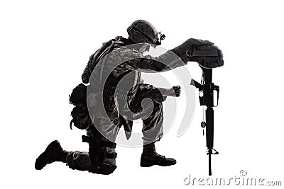 Sad soldier kneeling because of friend death Stock Photo