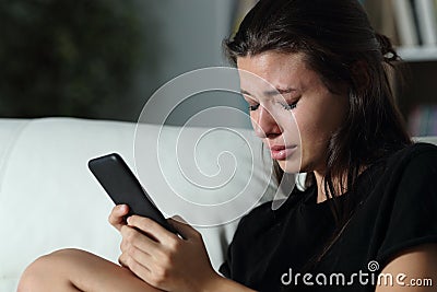 Sad teen crying after read phone message Stock Photo