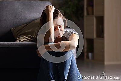 Sad teen at home in a dark living room Stock Photo