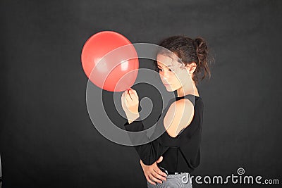 Sad teenage schoolgirl with red baloon Stock Photo