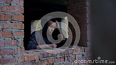 Sad teenager among abandoned house ruins, remembering family and childhood Stock Photo