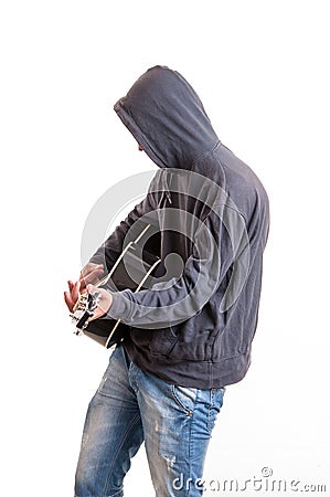 Sad teenager in black hoodie playing acoustic guitar Stock Photo