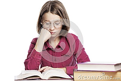 Sad teenager girl in glasses sits at a table with books, propping her head on her hand. Knowledge and education. Isolated on a Stock Photo