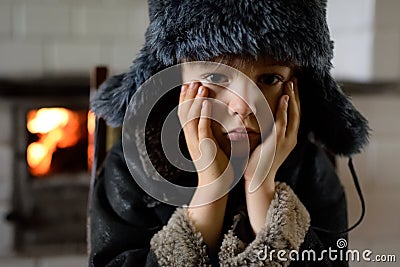 A sad, terrified, poor child. The boy in a winter, dark hat. Stock Photo