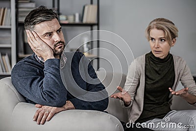 Tired husband in the middle of a fight with a cheating wife Stock Photo