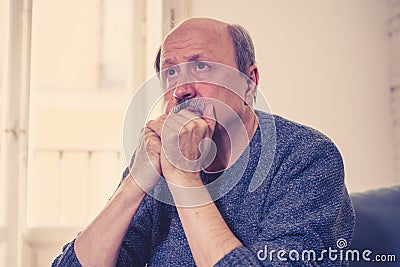 Sad unhappy old senior man suffering from memory loss and alzheimer feeling depressed and lonely Stock Photo