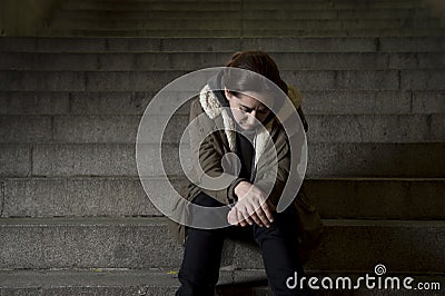 Sad woman alone on street subway staircase suffering depression looking looking sick and helpless Stock Photo