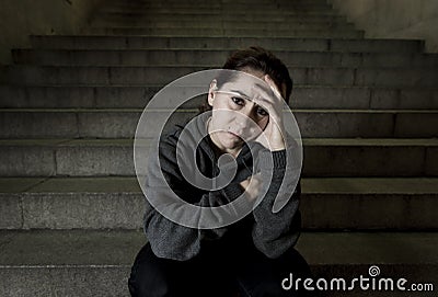 Sad woman alone on street subway staircase suffering depression looking looking sick and helpless Stock Photo