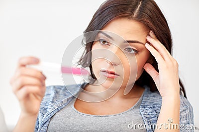 Sad woman looking at home pregnancy test Stock Photo